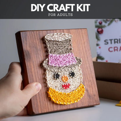 DIY craft kit for adults with a snowman string art design on a wooden board.
