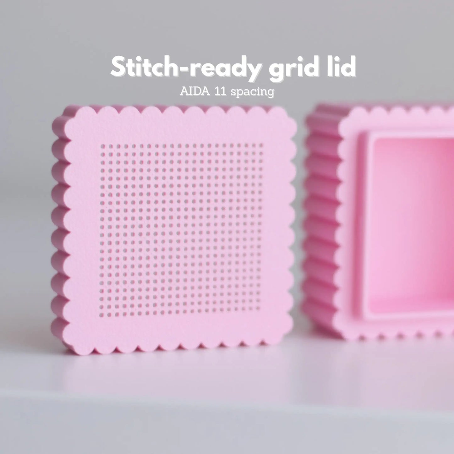 Pink mini cross stitch box lid showing perforated stitching grid with AIDA 11 spacing and removable clip inside