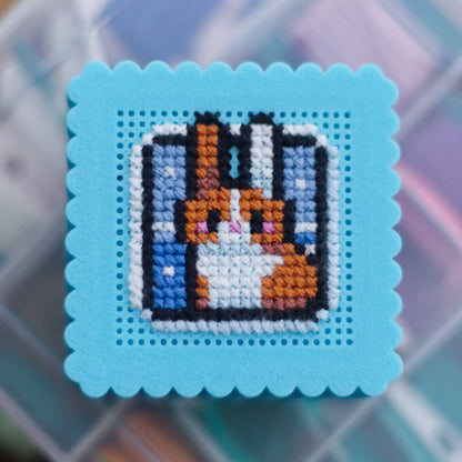 Blue mini cross stitch box lid with completed bunny embroidery showing detail of stitched design on perforated surface