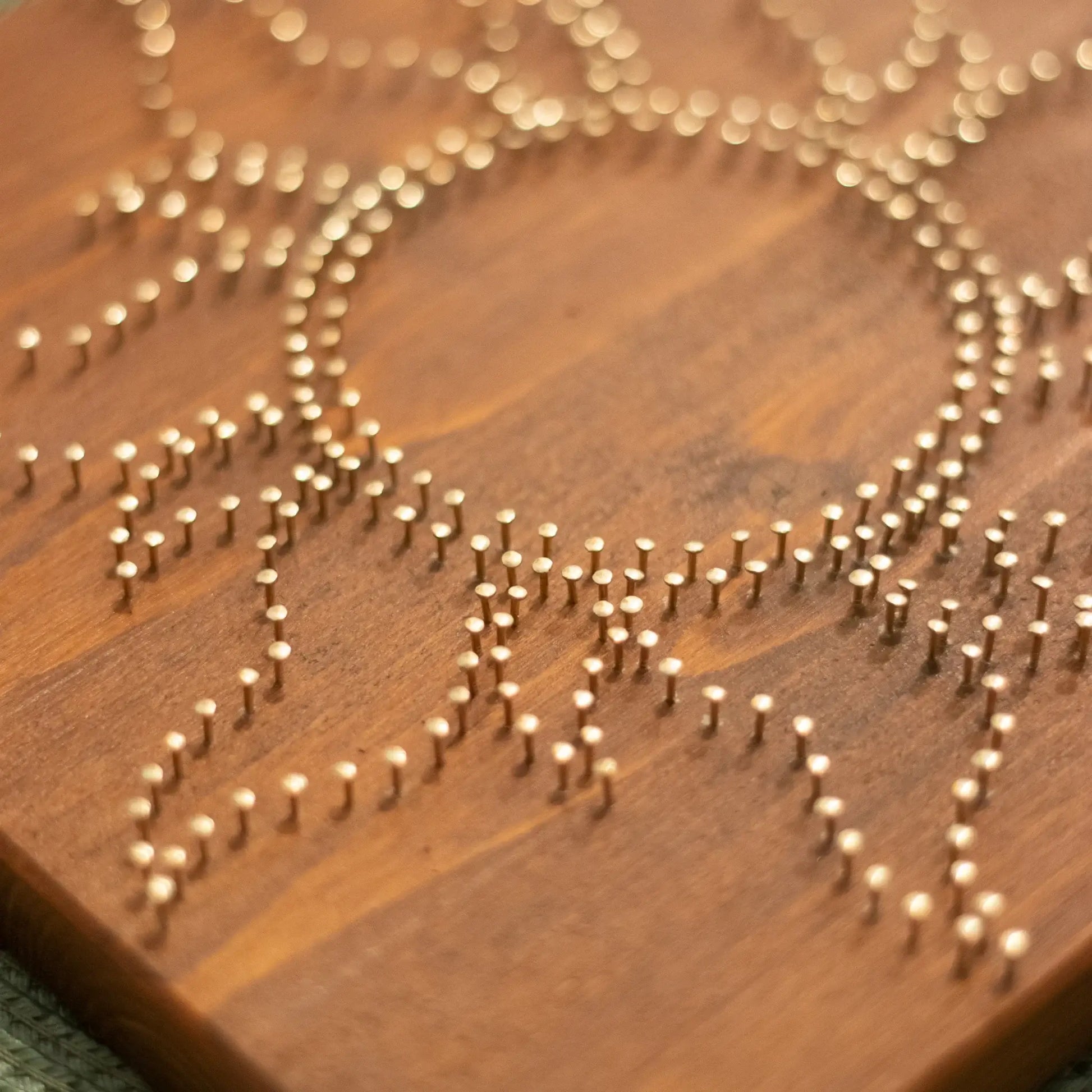 In process view of a vibrant yellow sun string art design on a wooden background, perfect for adding a touch of sunshine to any space. Available as a digital pattern.