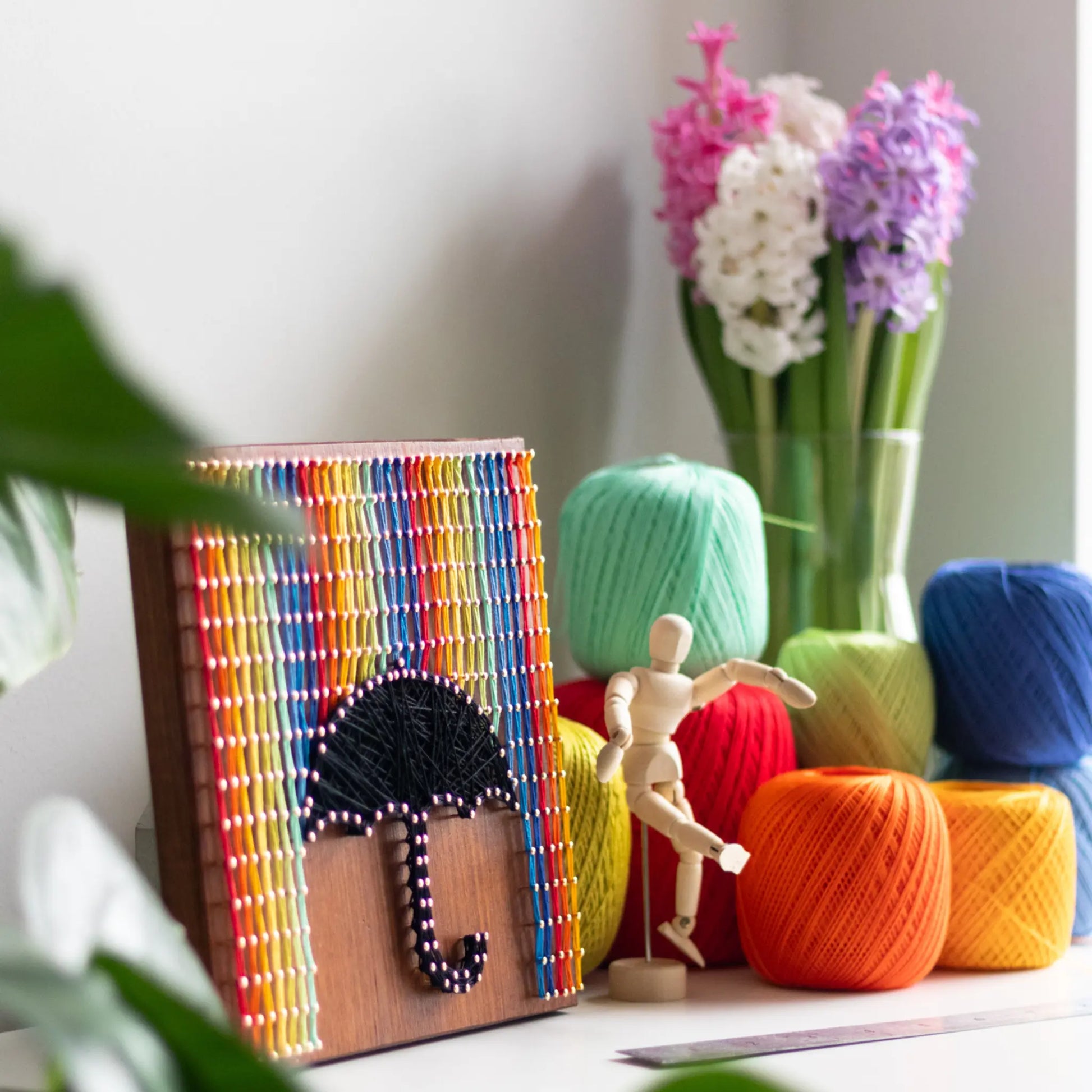 Rainbow and umbrella string art design, ready to display as home decor.