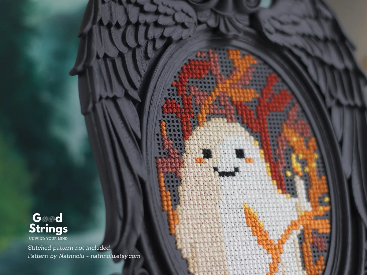 Black angel wing embroidery frame stitched with a cute ghost pattern, close-up of feathered wings and perforated grid