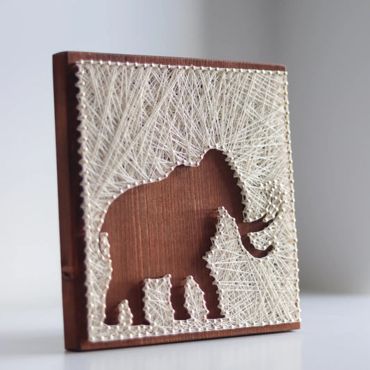 DIY string art kit with a woolly mammoth design, highlighting the detailed craftsmanship of the wooden base and white thread patterns.